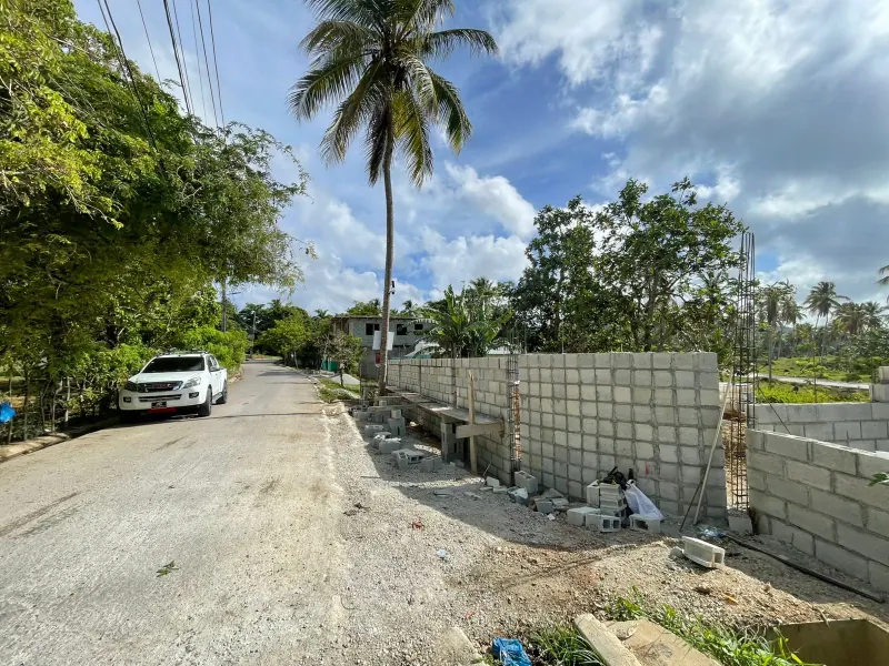 A block boundary wall under construction beside the road
