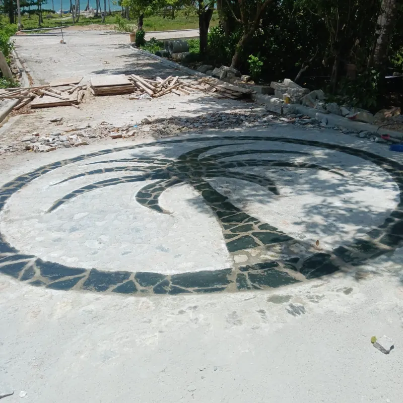 A palm tree mosaic set in stone on the entrance drive